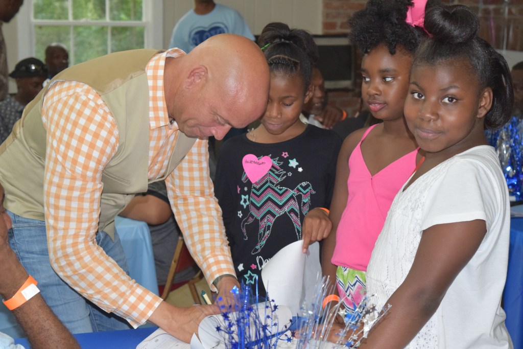 Mayor Grennell signs posters for the kids